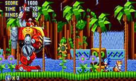 Sonic and Tails fighting Eggman in Green Hill Zone in Sonic Mania.